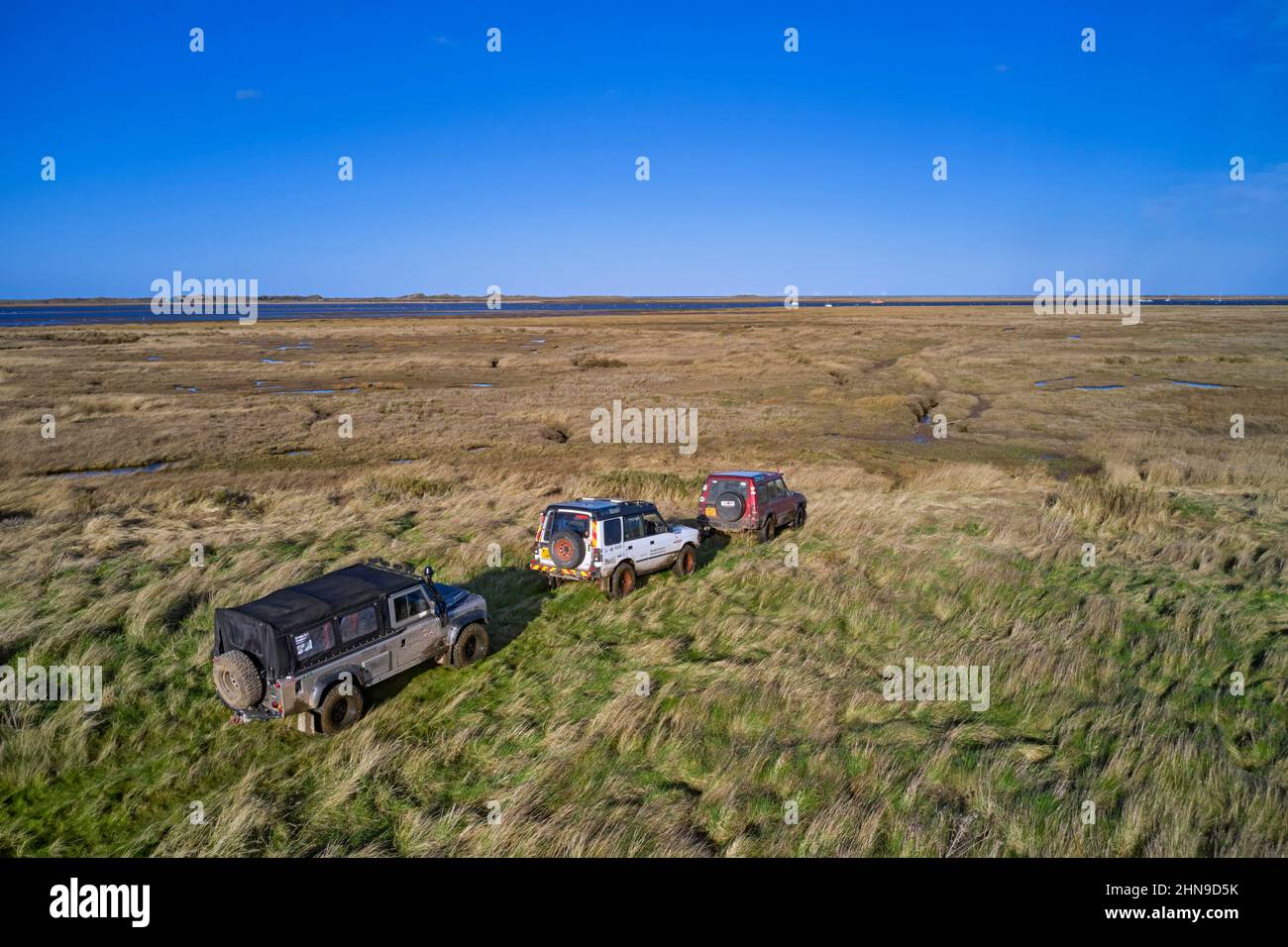 Land Rovers stop where the byway ends at the edge of the salt marshes. Morston Greens, Norfolk, England. Stock Photo