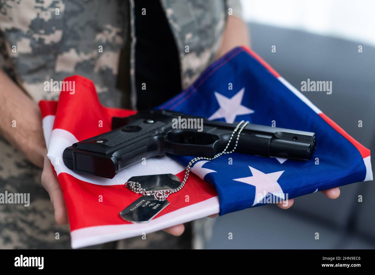 American soldier stands against white background with a flag. Concept ...