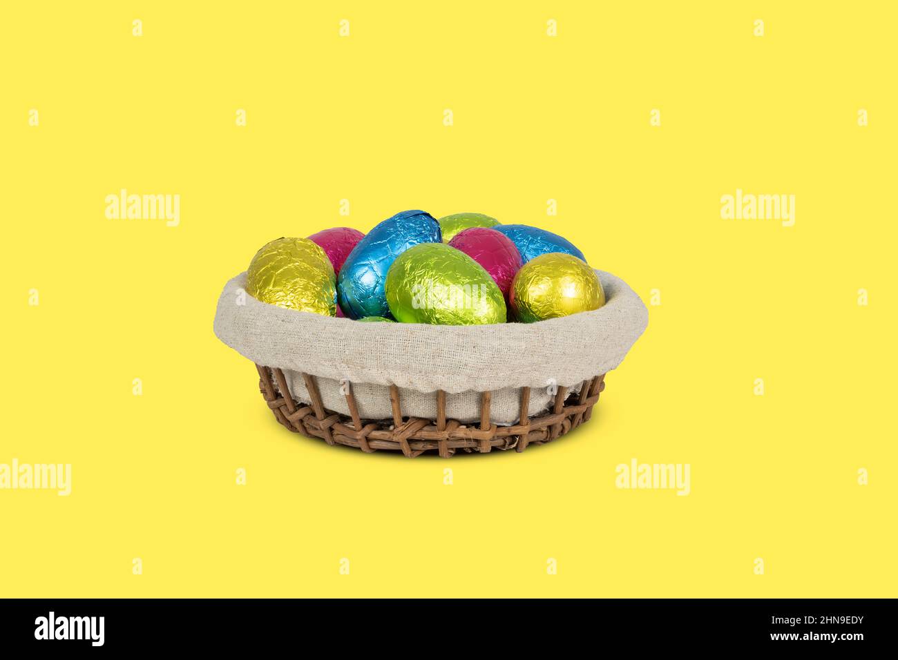Basket with colorful wrapped Easter egss. Stock Photo
