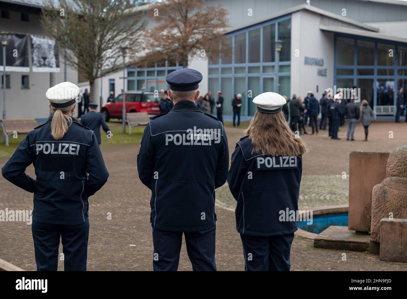 Freisen, Germany. 15th Feb, 2022. Police officers stand in front of the Bruchwald Hall waiting for the broadcast of the funeral of the police commissioner who was shot dead with a female police colleague during a vehicle check near Kusel in Rhineland-Palatinate on January 31, 2022. Two weeks after the fatal shooting of two police officers in the western Palatinate, the 29-year-old police commissioner will be buried on Tuesday in his hometown of Freisen in Saarland. Credit: Harald Tittel/dpa/Alamy Live News Stock Photo