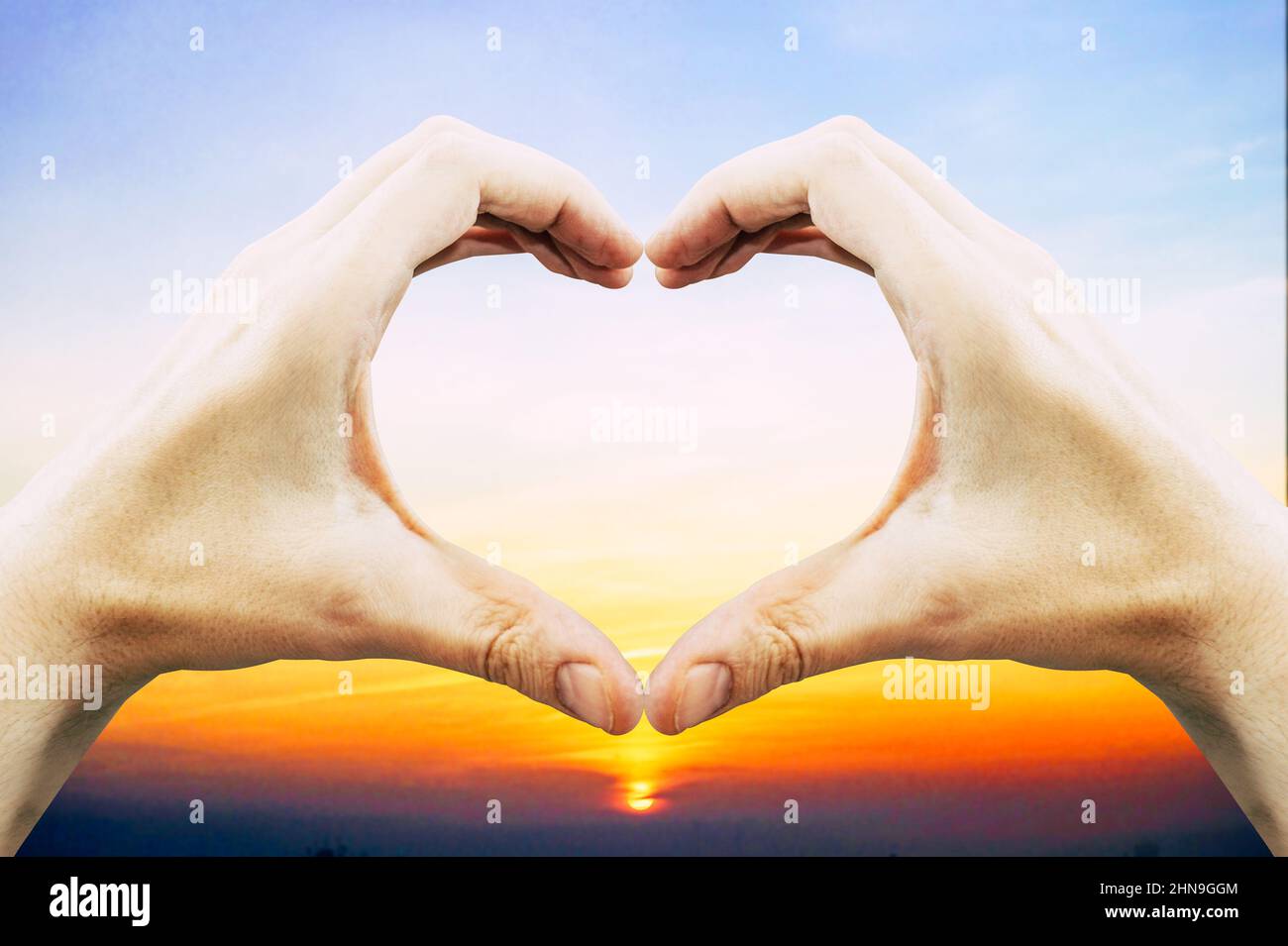Hands forming heart shape, sunset sky in background - love concept ...