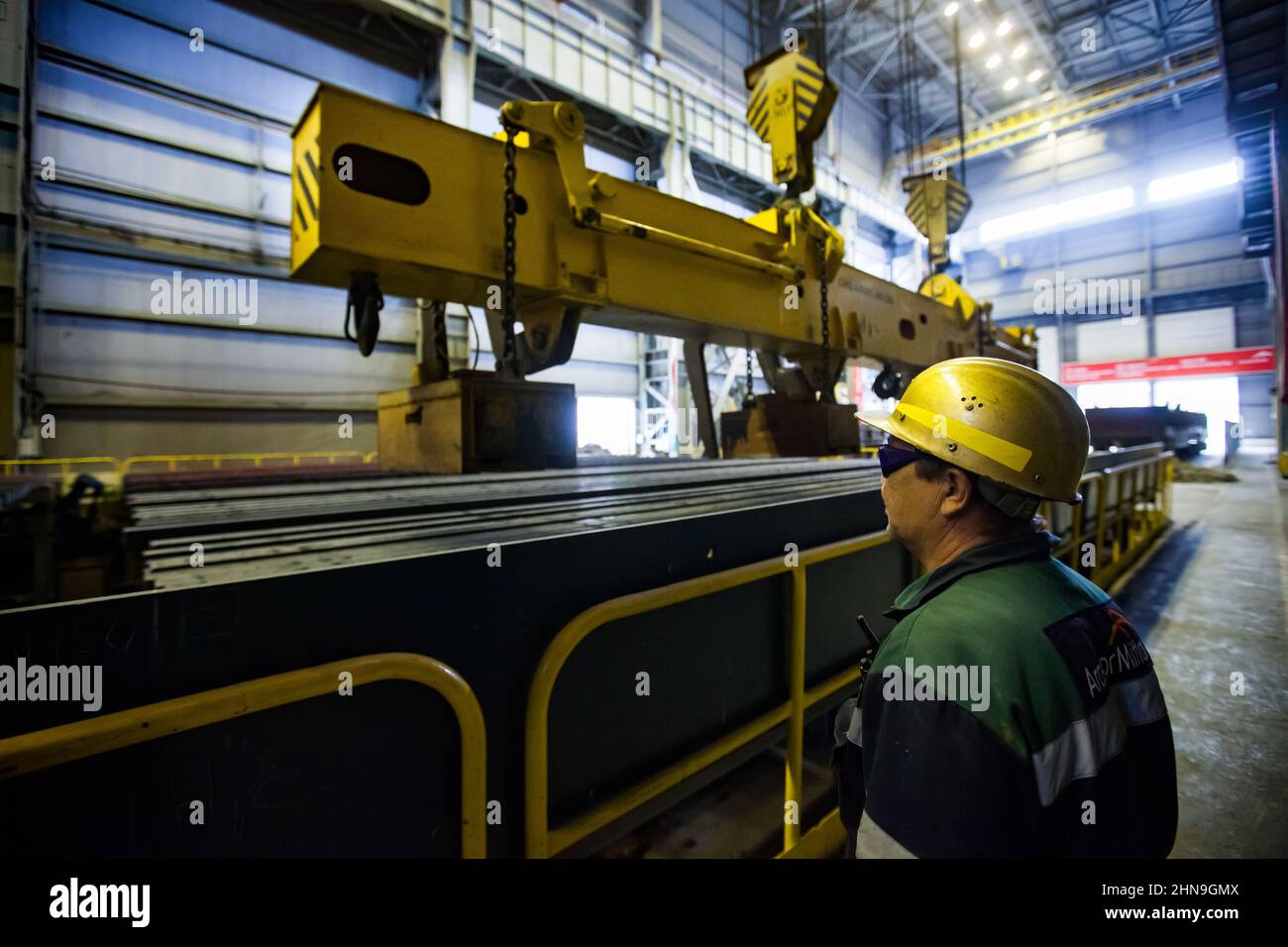 Temirtau, Kazakhstan - June 08, 2012: Arcelor Mittal metallurgy plant. Steel manufacturing. Worker, conveyor belt and crane. Lifting magnet WOKO for s Stock Photo