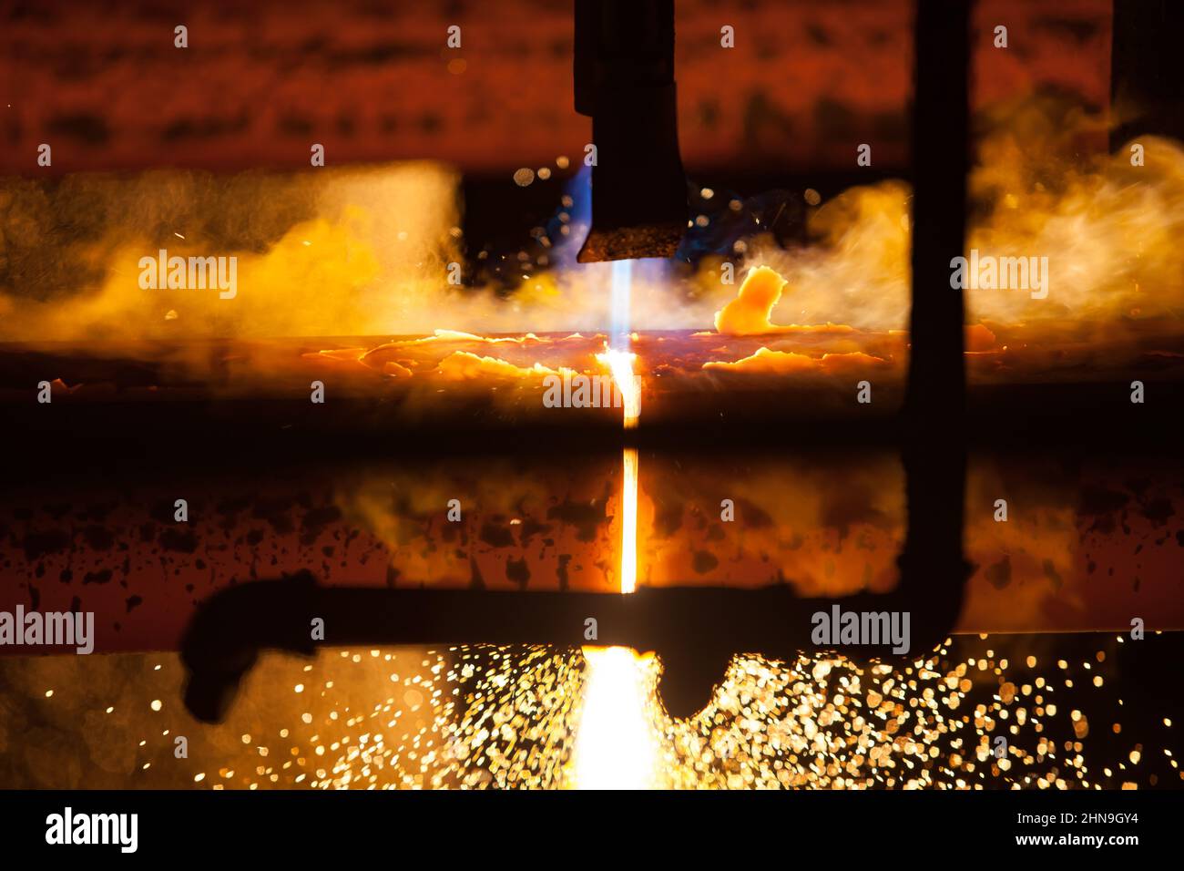 Manufacturing of mild steel square bar on continuous casting machine. Cutting bars by gas torch, close-up photo. Stock Photo
