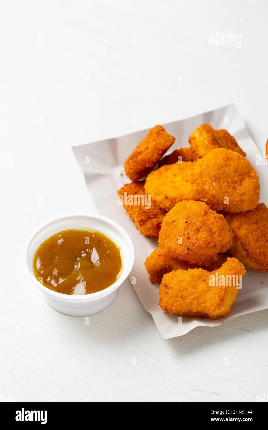 Chunchy chicken nuggets and mustard sauce on light surface Stock Photo