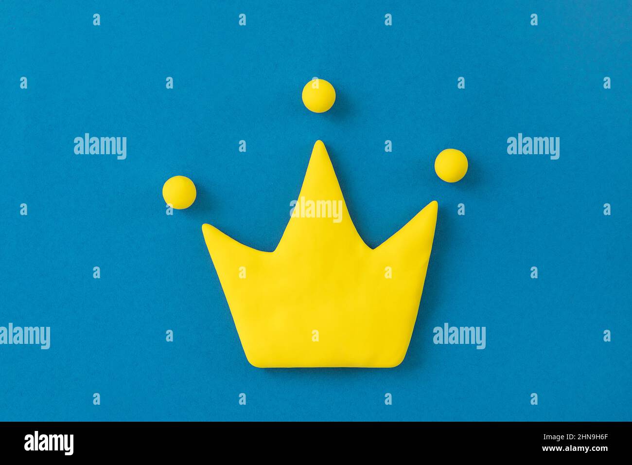 Simple 3d yellow crown symbol on blue background. Concept of win and success, top rank quality status. Stock Photo
