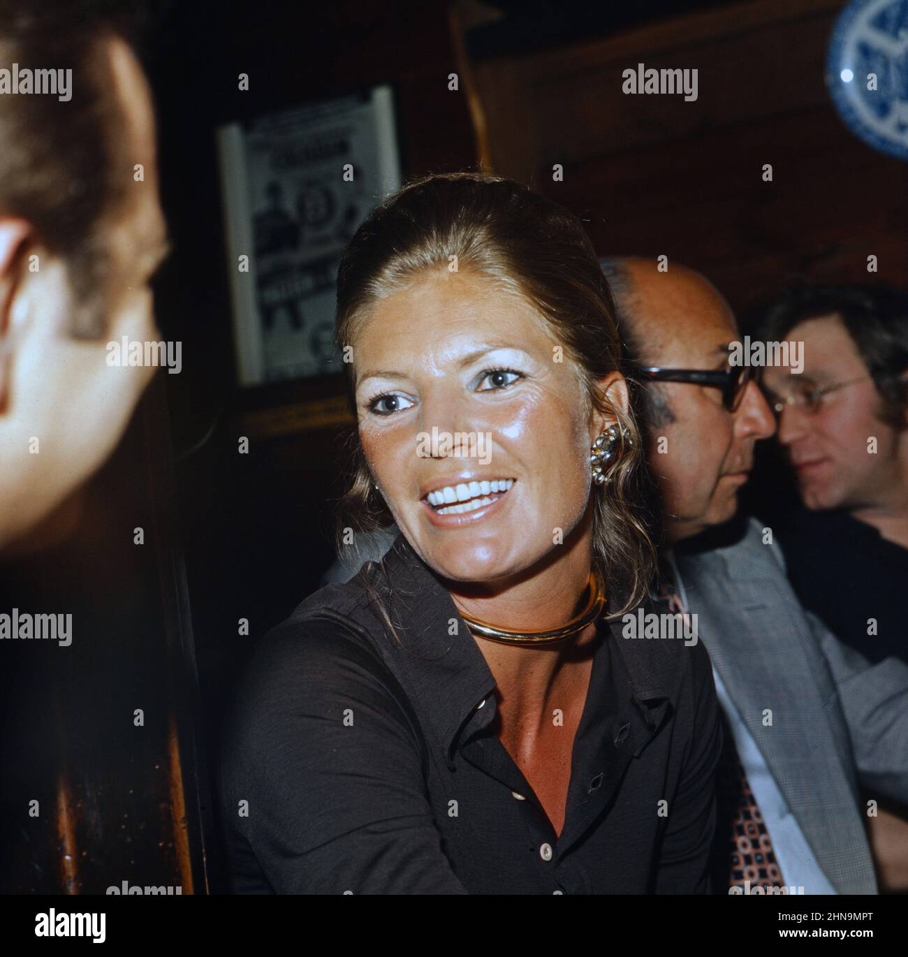 Regisseur Franz Antel hinter seiner Ehefrau Elisabeth bei einer Feier während der Dreharbeiten zum Spielfilm 'Die gelbe Nachtigall', Österreich um 1974. Stock Photo