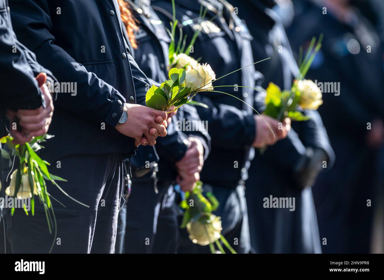 Kusel, Rhineland-Palatinate. 31st Jan, 2022. 15 February 2022, Saarland, Freisen: Policewomen with flowers stand outside the Bruchwald Hall during the broadcast of the funeral of a police commissioner who was shot dead with a female police colleague during a vehicle check near Kusel, Rhineland-Palatinate, on Jan. 31, 2022. Two weeks after the fatal shooting of the two police officers in the western Palatinate, the 29-year-old police commissioner will be buried on Tuesday in his hometown of Freisen in Saarland. Credit: Harald Tittel/dpa/Alamy Live News Stock Photo