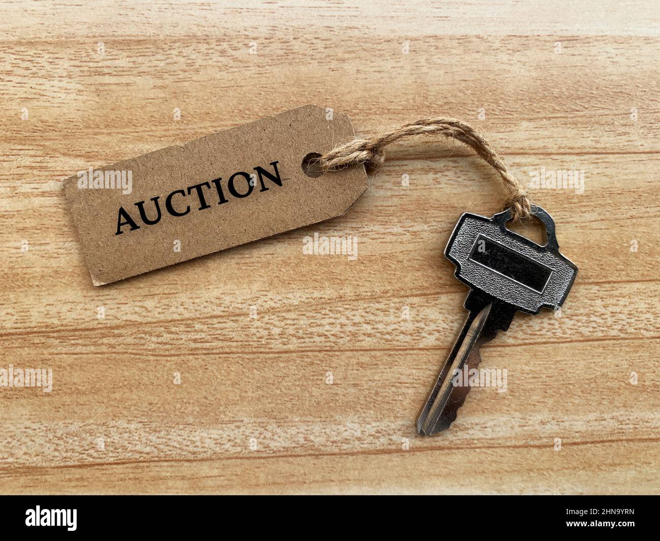 Text on brown tag with house key and wooden table background - Auction ...