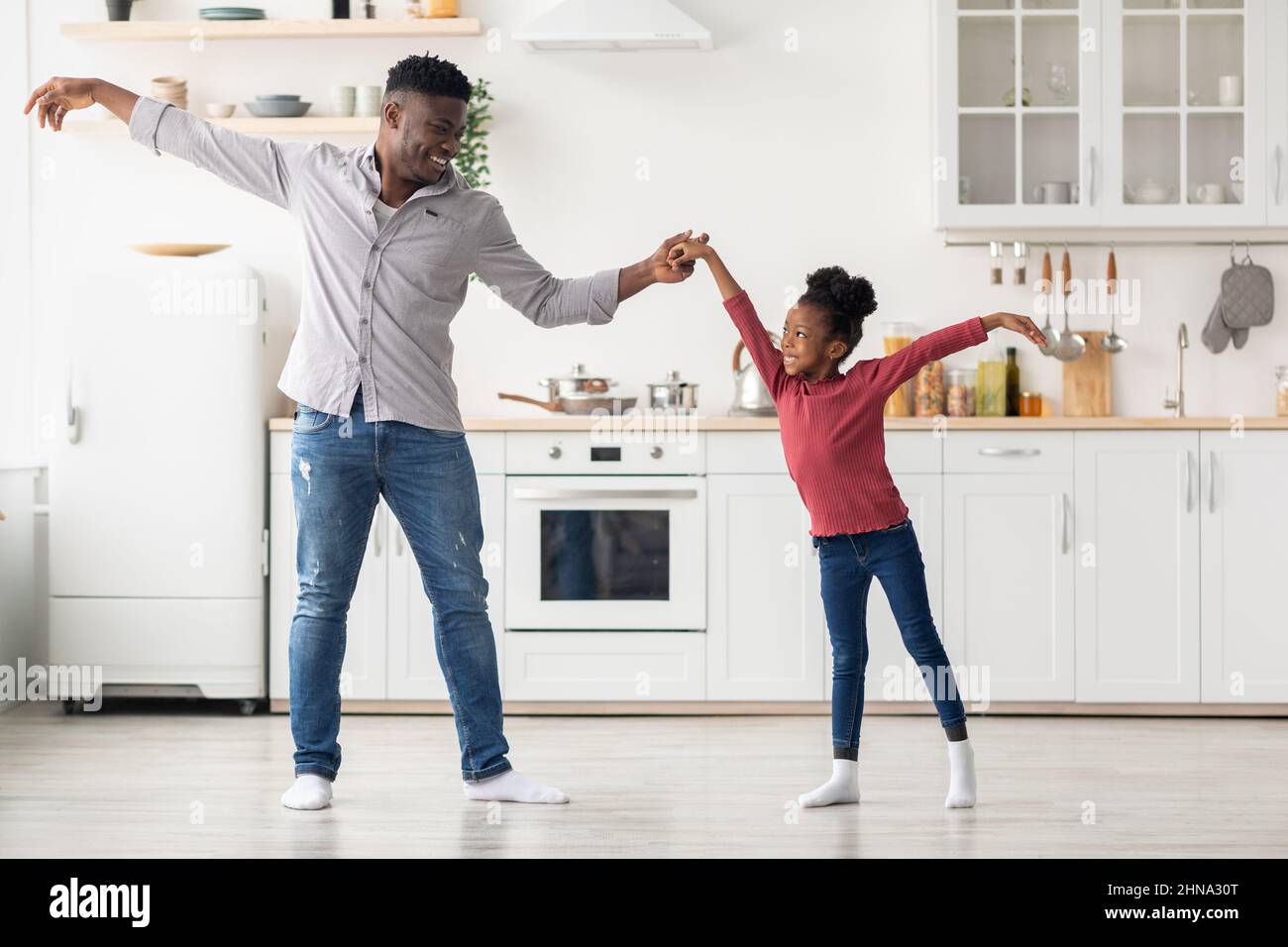 Cute black father and daughter dancing at kitchen Stock Photo
