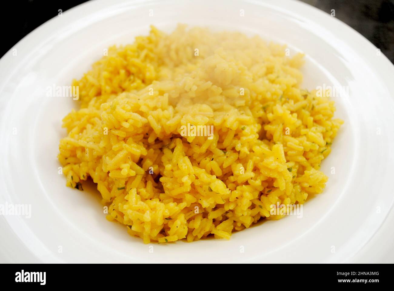 Side Dish of Steaming Herb and Yellow Rice Stock Photo