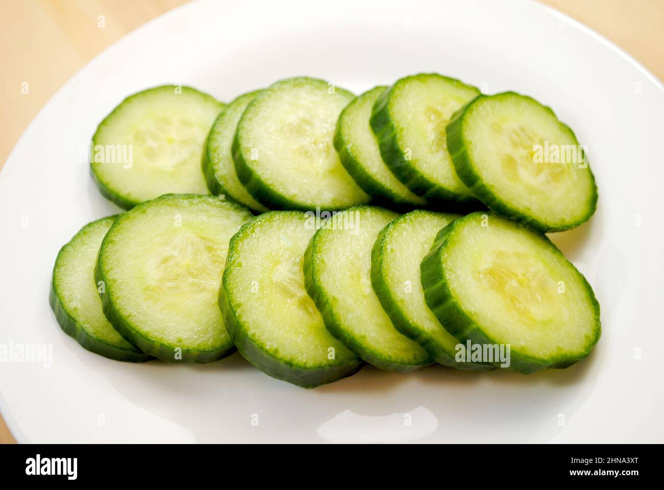 Burpless Cucumber Slices on a White Plate Stock Photo