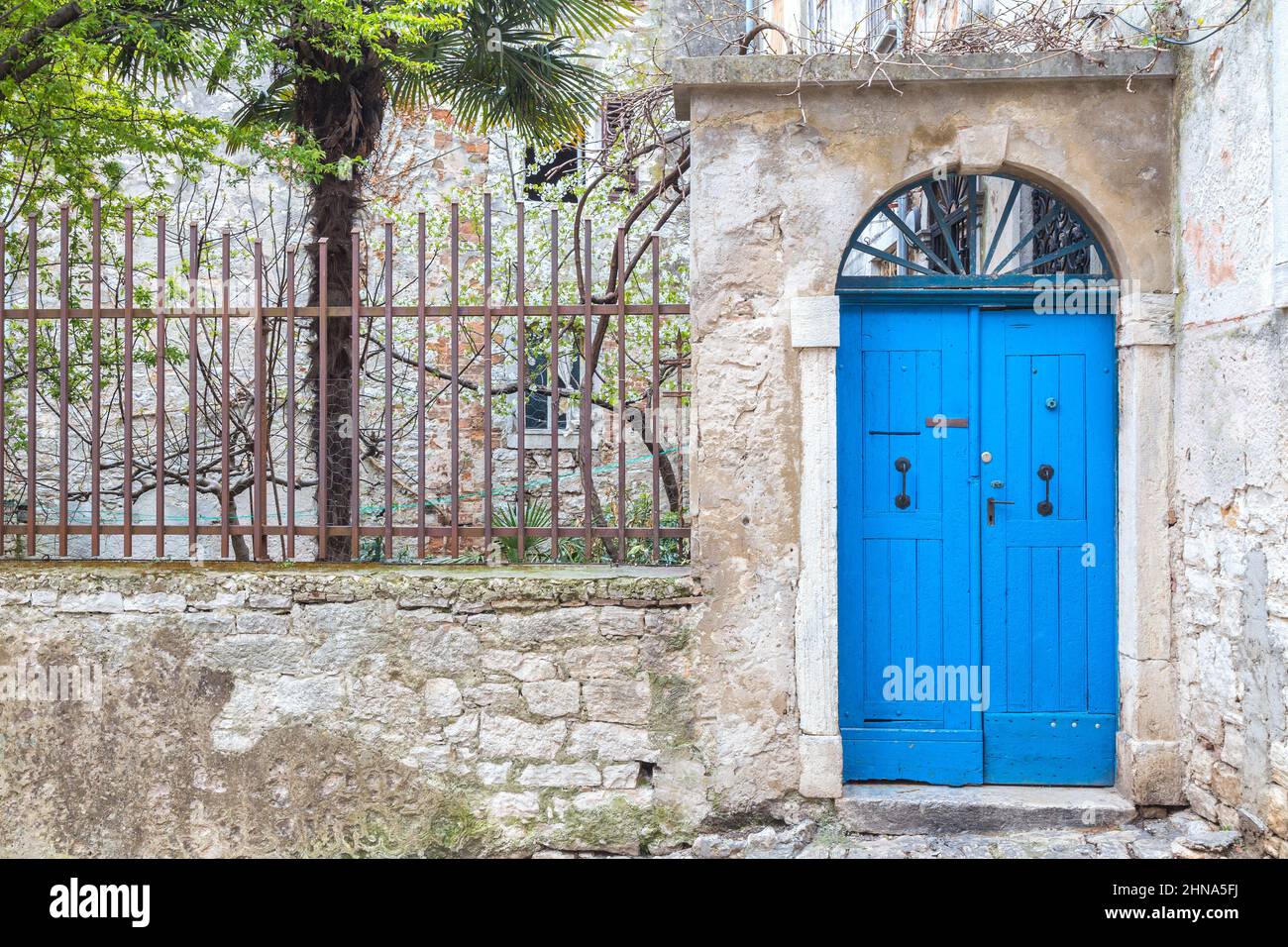 Stone facade with a blue entrance door of an old house in Rovinj ...