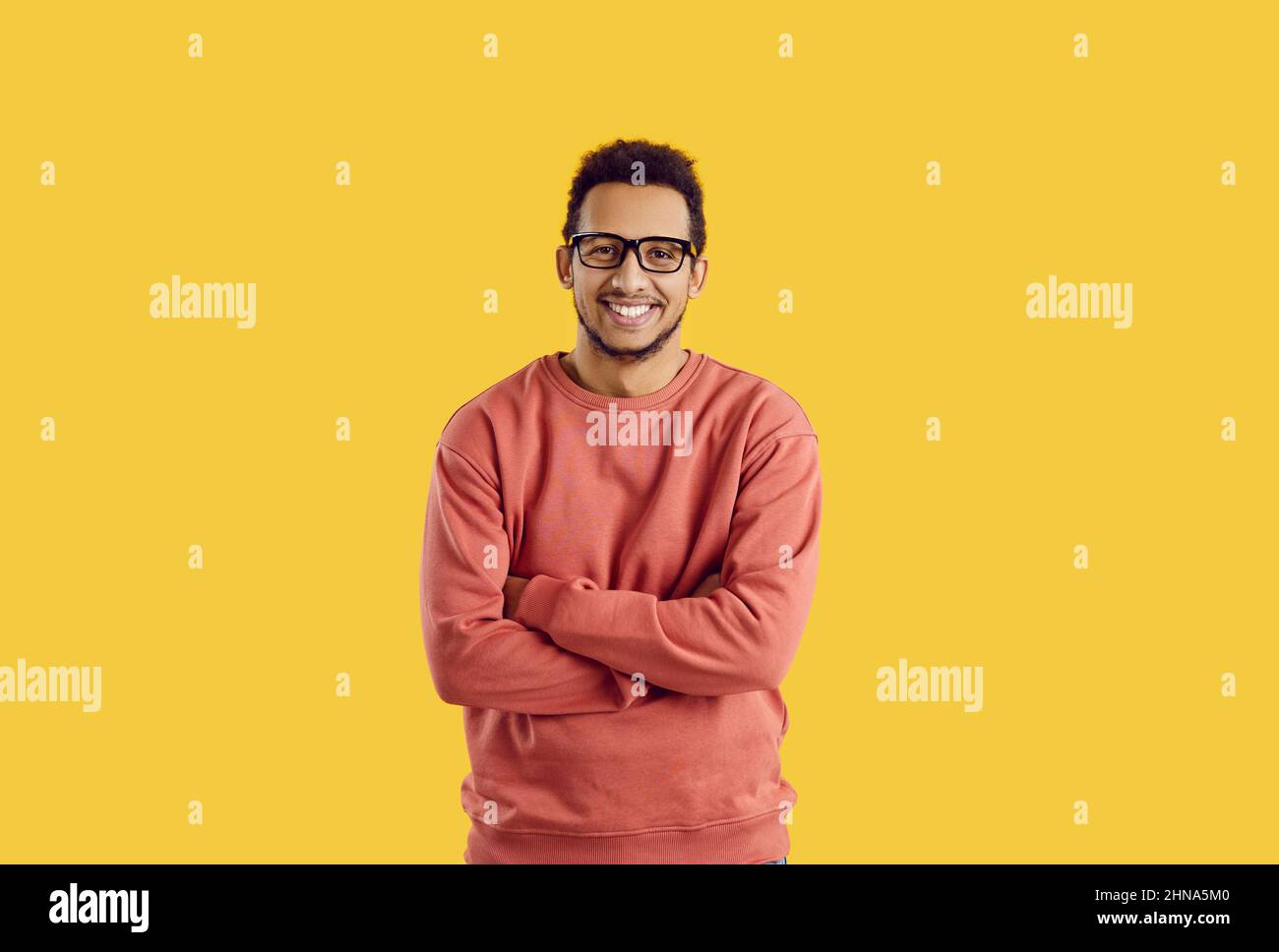 Portrait of happy young black man in glasses standing isolated on color background Stock Photo