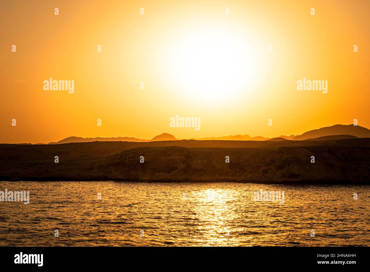 Beautiful yellow sunset on the red sea. bright yellow sun in the sky . Stock Photo