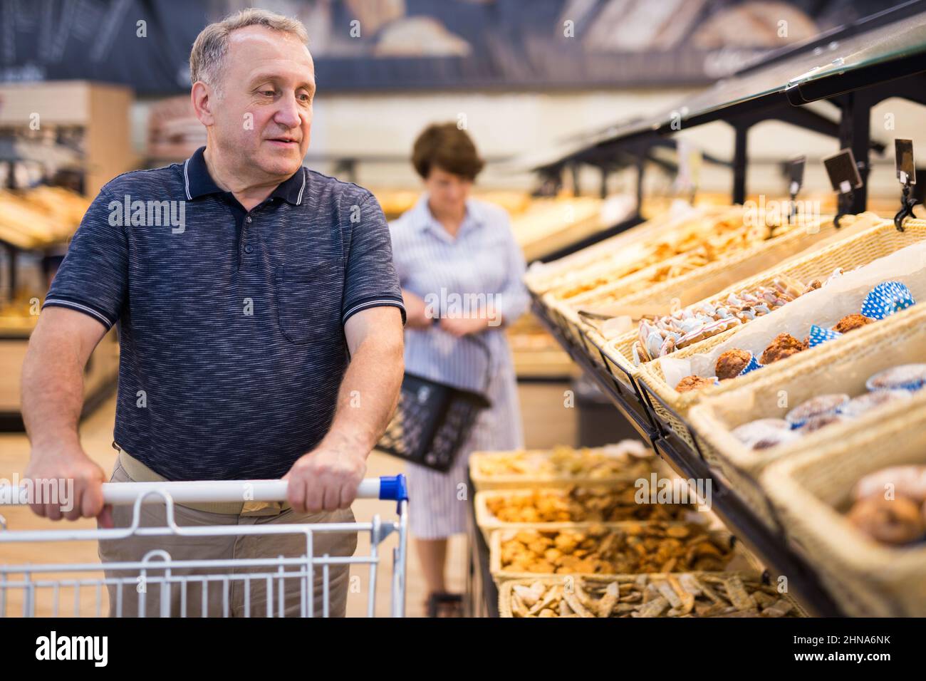 mature man choosing bread and baking in grocery section of supermarket Stock Photo