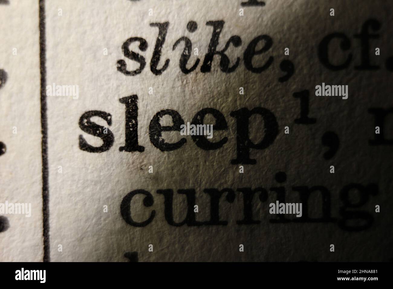 Word 'sleep' printed on dictionary page, macro close-up Stock Photo