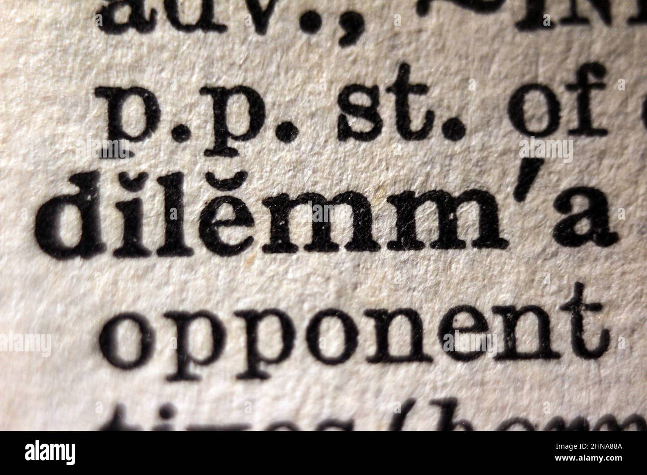 Word 'dilemma' printed on dictionary page, macro close-up Stock Photo