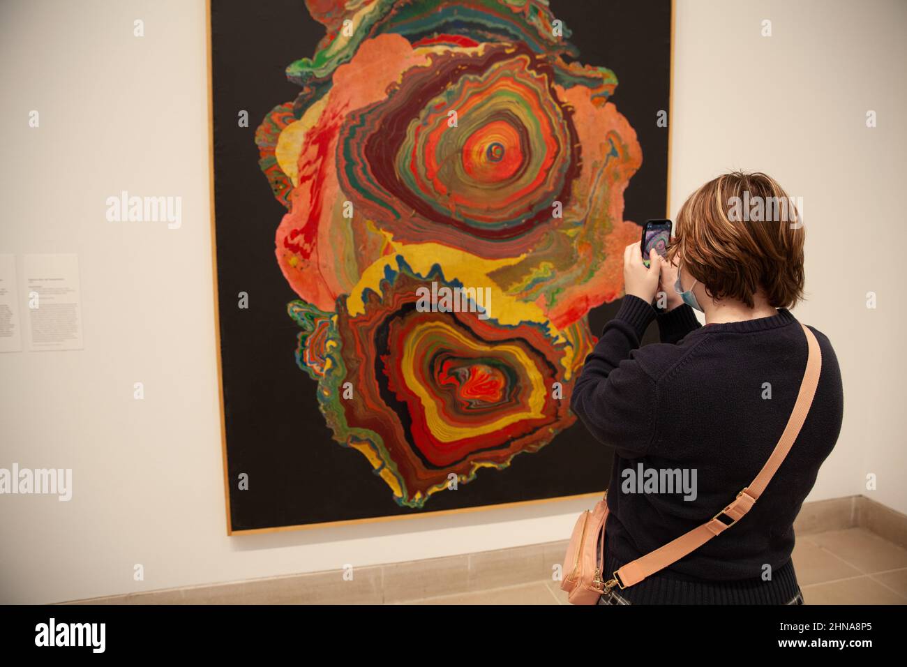 Teenage girl taking a picture with her phone of modern art work at a museum. Stock Photo