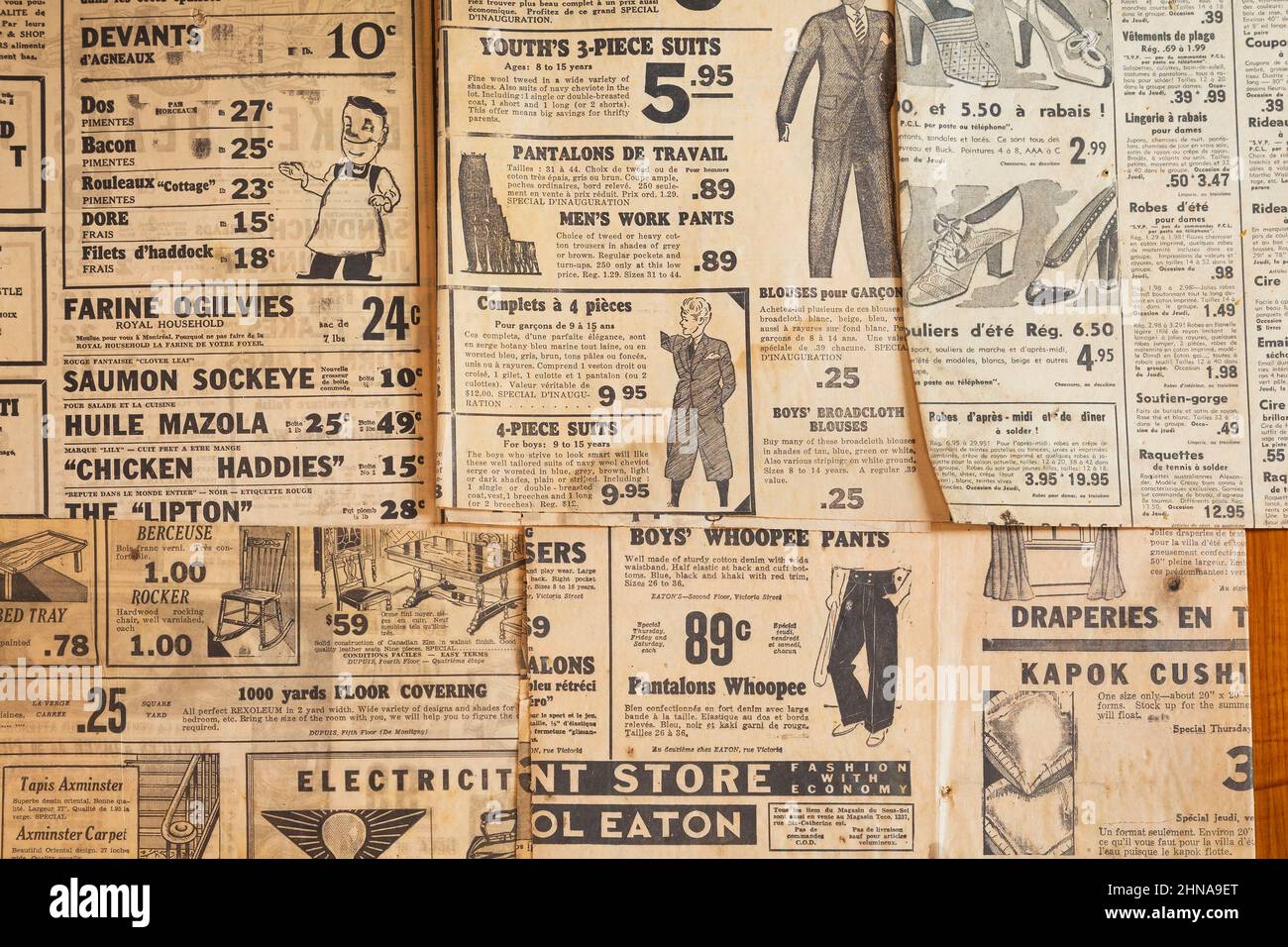Bilingual French and English worded clothing and product advertisements printed in old newspapers from 1930s, 40s, 50s. Stock Photo
