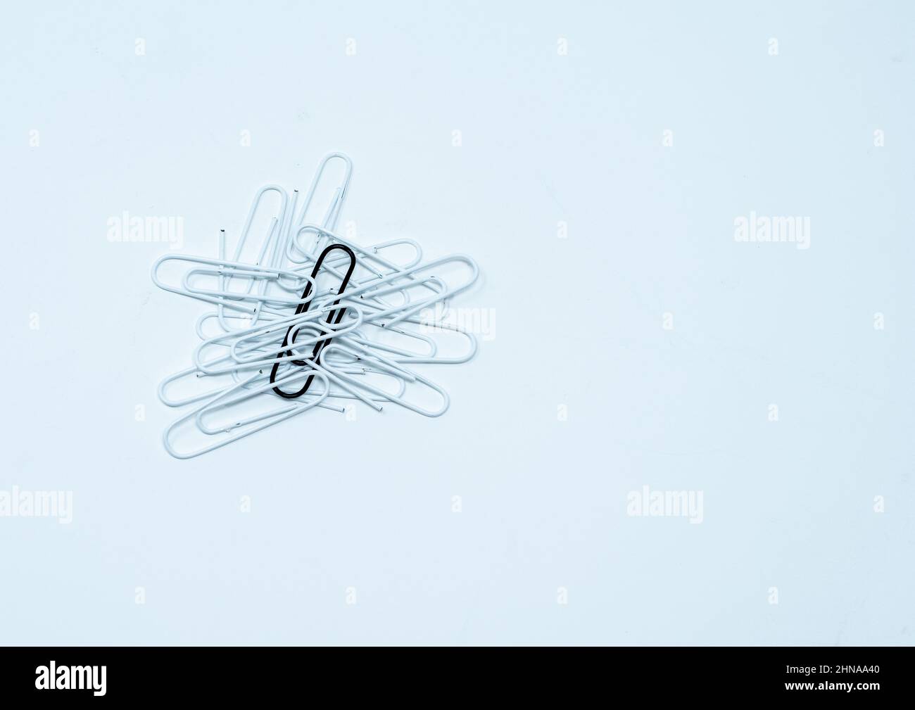Multi coloured, black and white paper clips in a pile on a plain white background. Stock Photo