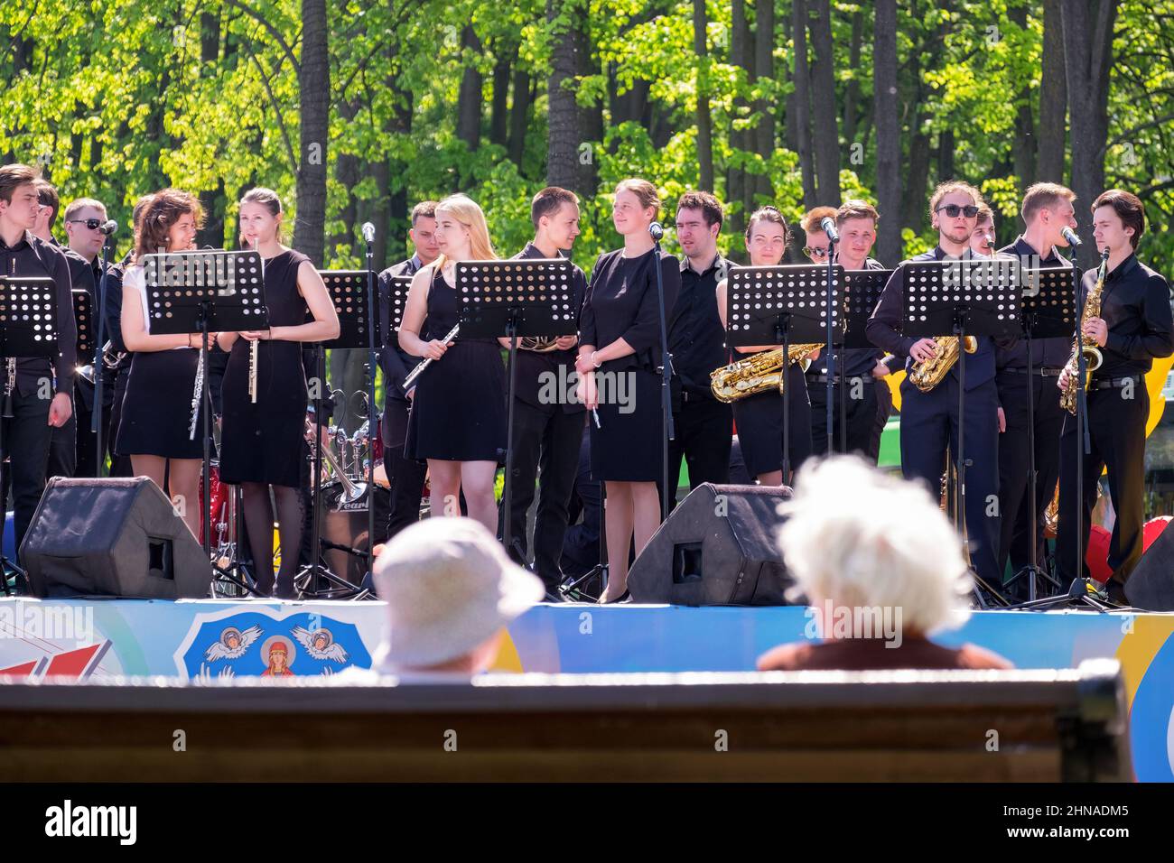 A brass band of young musicians is preparing for an outdoor performance. The audience is elderly women. Spring. Minsk (Belarus). May 9, 2018. Stock Photo