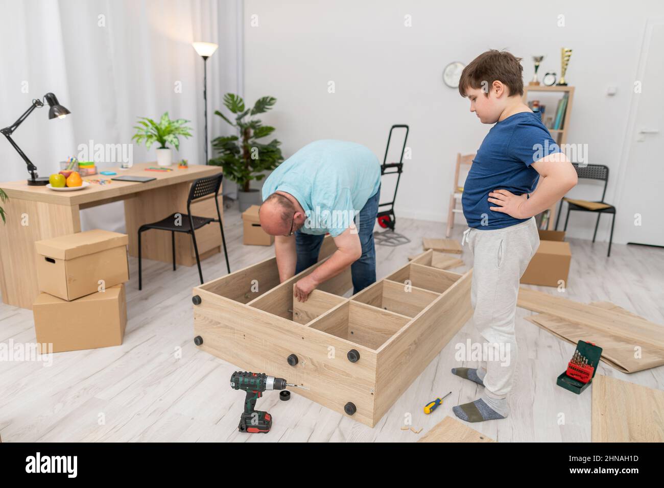 Dad assembles the furniture and son supervises the assembly process ...