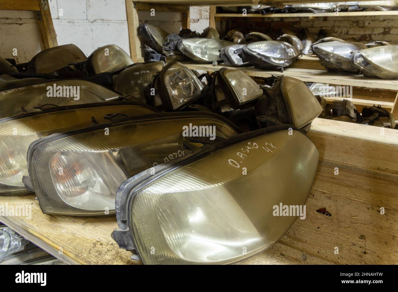 Used headlamp components for sale on the store shelf. Used auto parts for sale in a store in a landfill. Headlights for different kind of cars. Disass Stock Photo