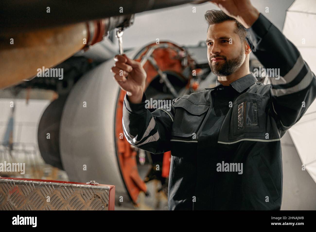 Male aviation mechanic repairing airplane in hangar Stock Photo