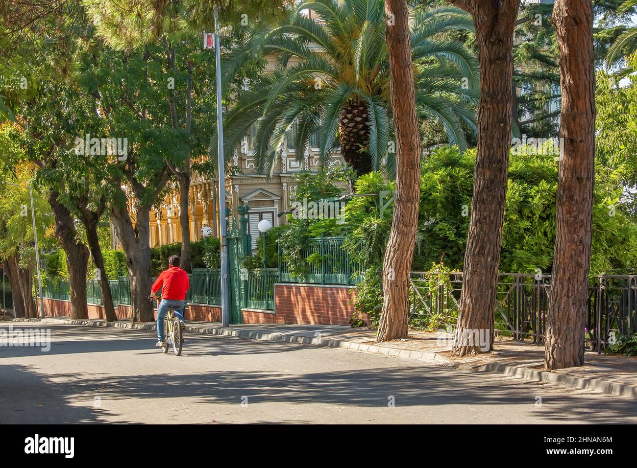 Man drives bicycle down empty street of Buyukada island, Turkey Stock Photo