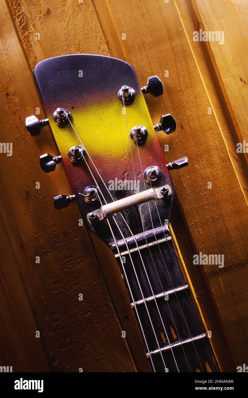 Closeup view of a neck and colorful head of an old guitar. Stock Photo