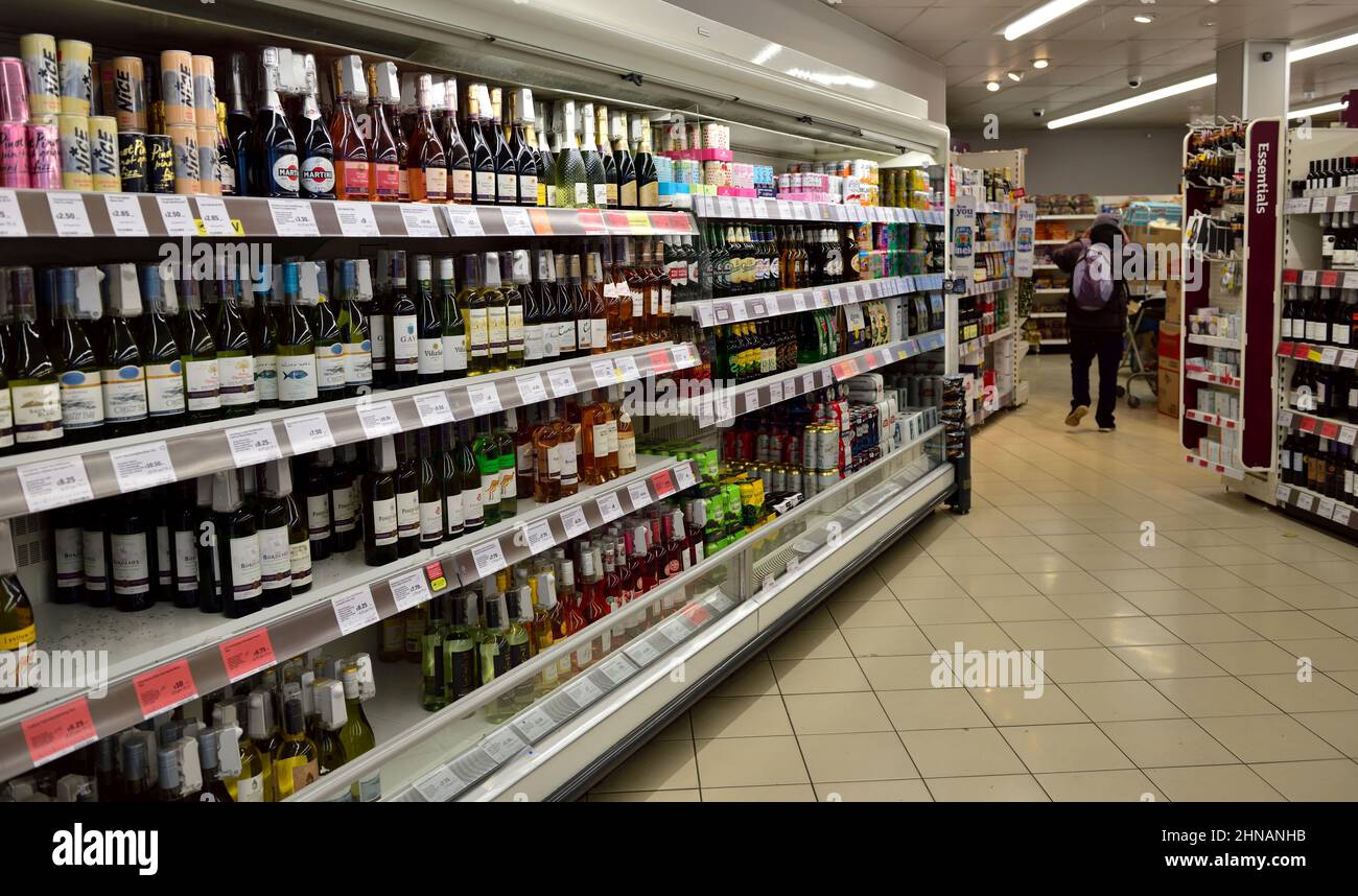 Supermarket aisle with wines and spirits leading into beers and other products, UK Stock Photo