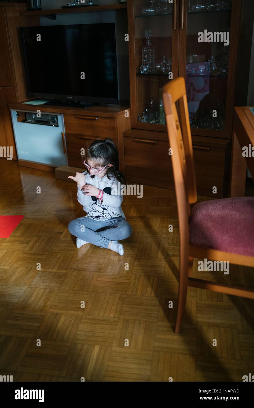 little girl sitting cross-legged on the floor Stock Photo - Alamy