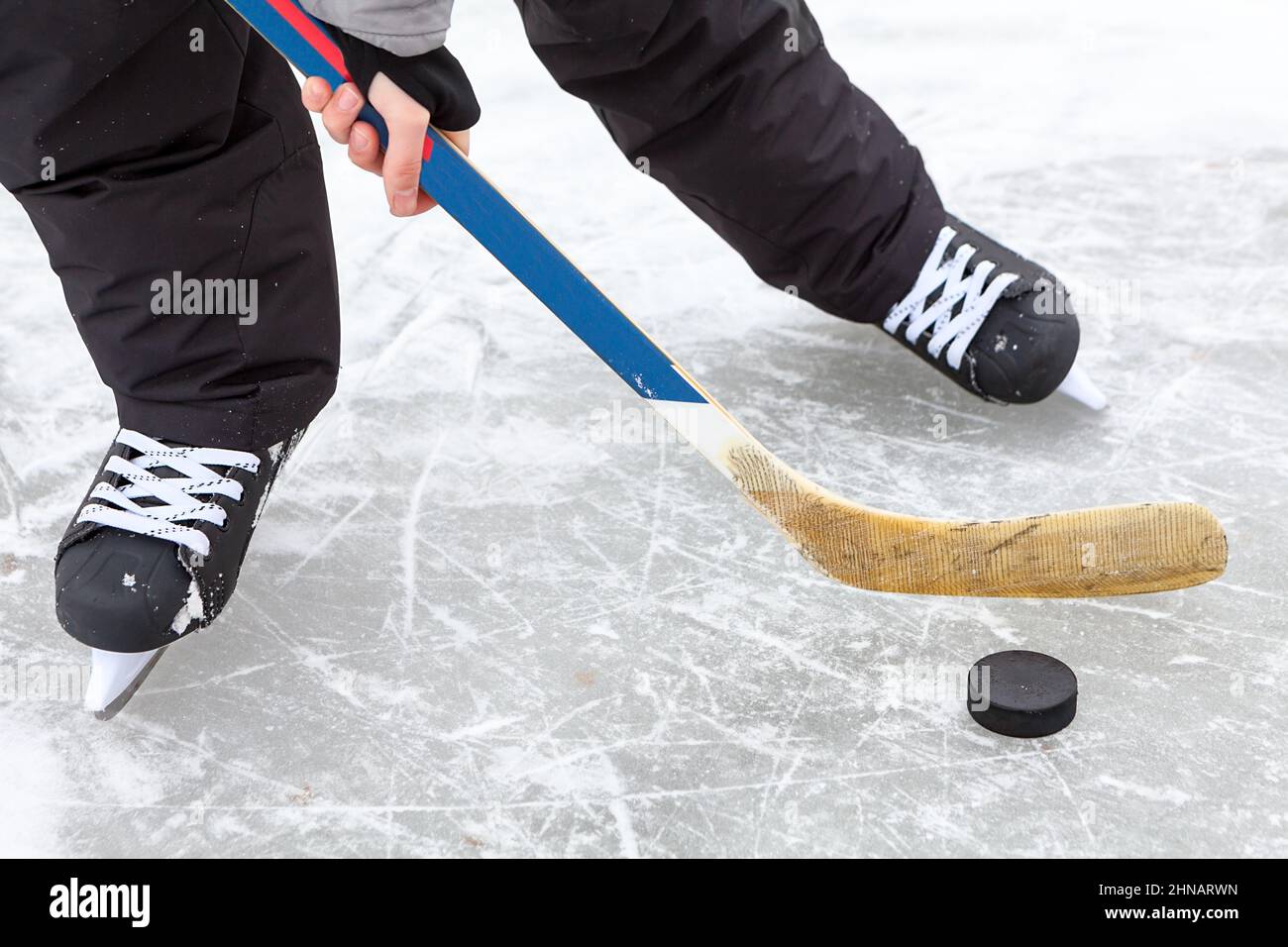 Hockey man runs with blade of stick and puck, close up view Stock Photo