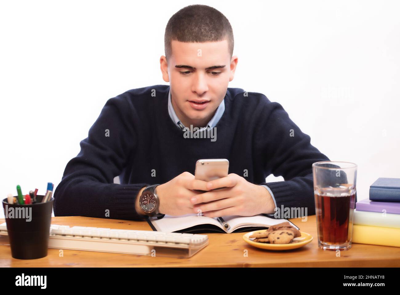 young men writing in a book and working in the computer at home, online ...