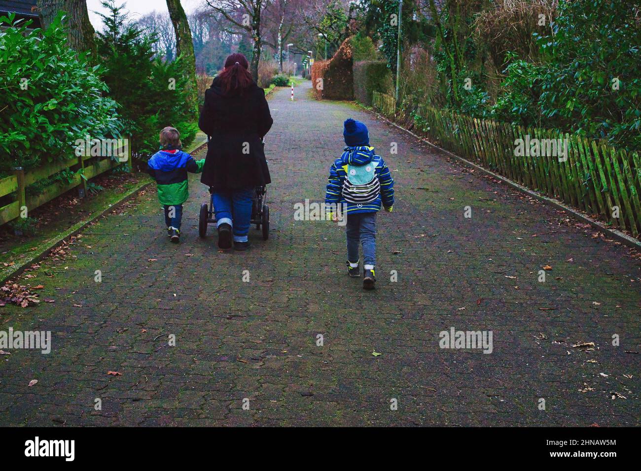 Mother with stroller and small children taking a walk Stock Photo