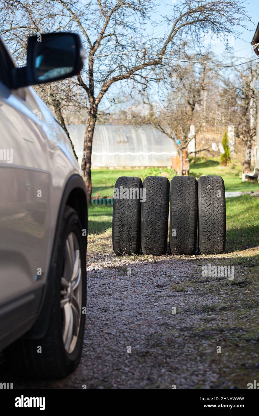 Four winter and snow used wheels are ready for change before snowfall at autumn or spring season Stock Photo