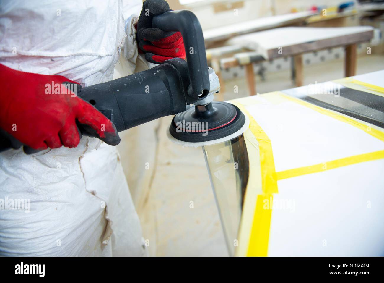 A carpenter polishing the edges of an epoxy resin table Stock Photo