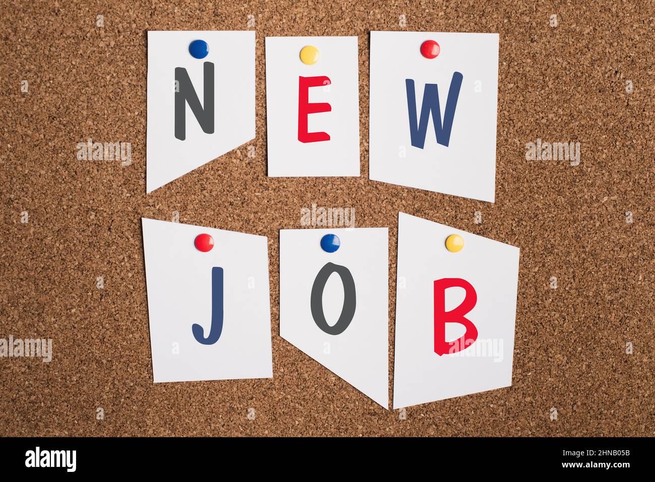 The words new job are standing on paper pinned to a corkboard, finding