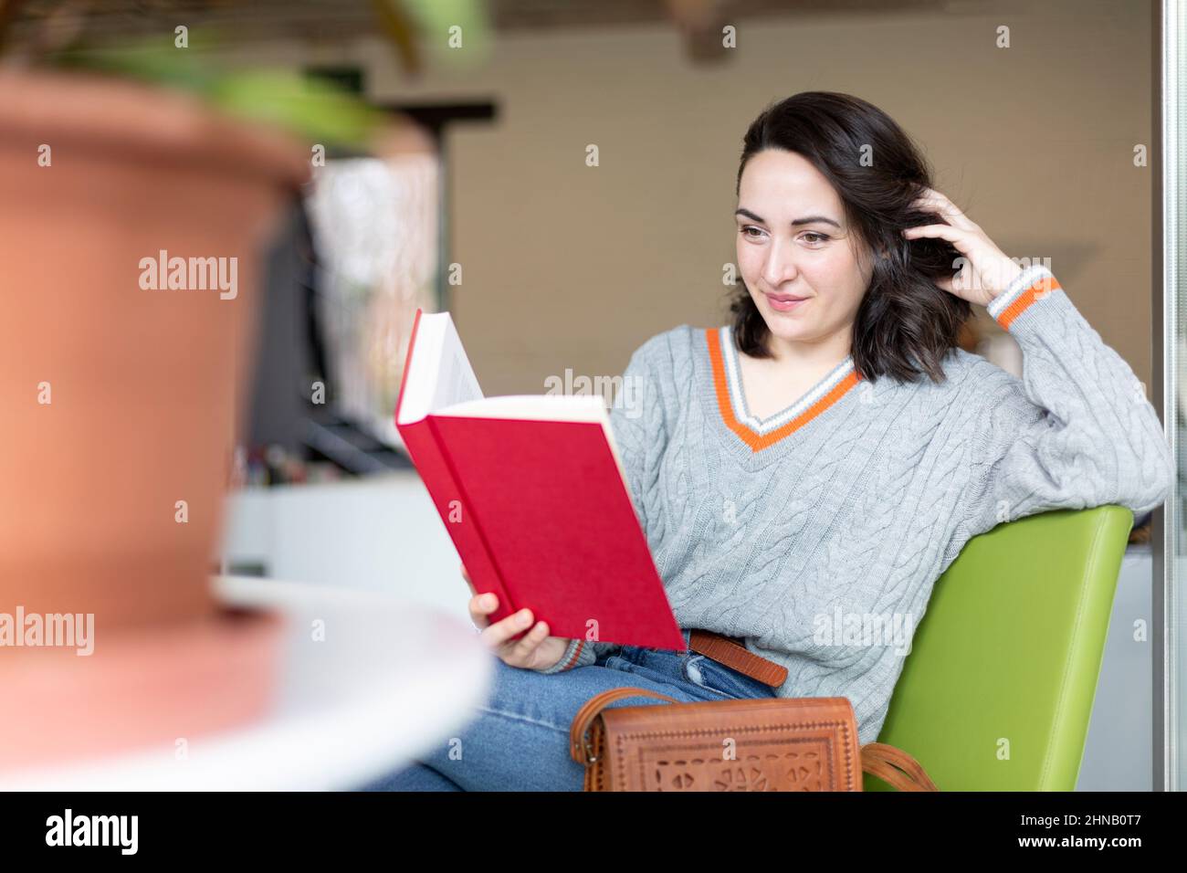 Young Caucasian woman enjoying reading a book. Hobbies and pastimes. Space for text. Stock Photo