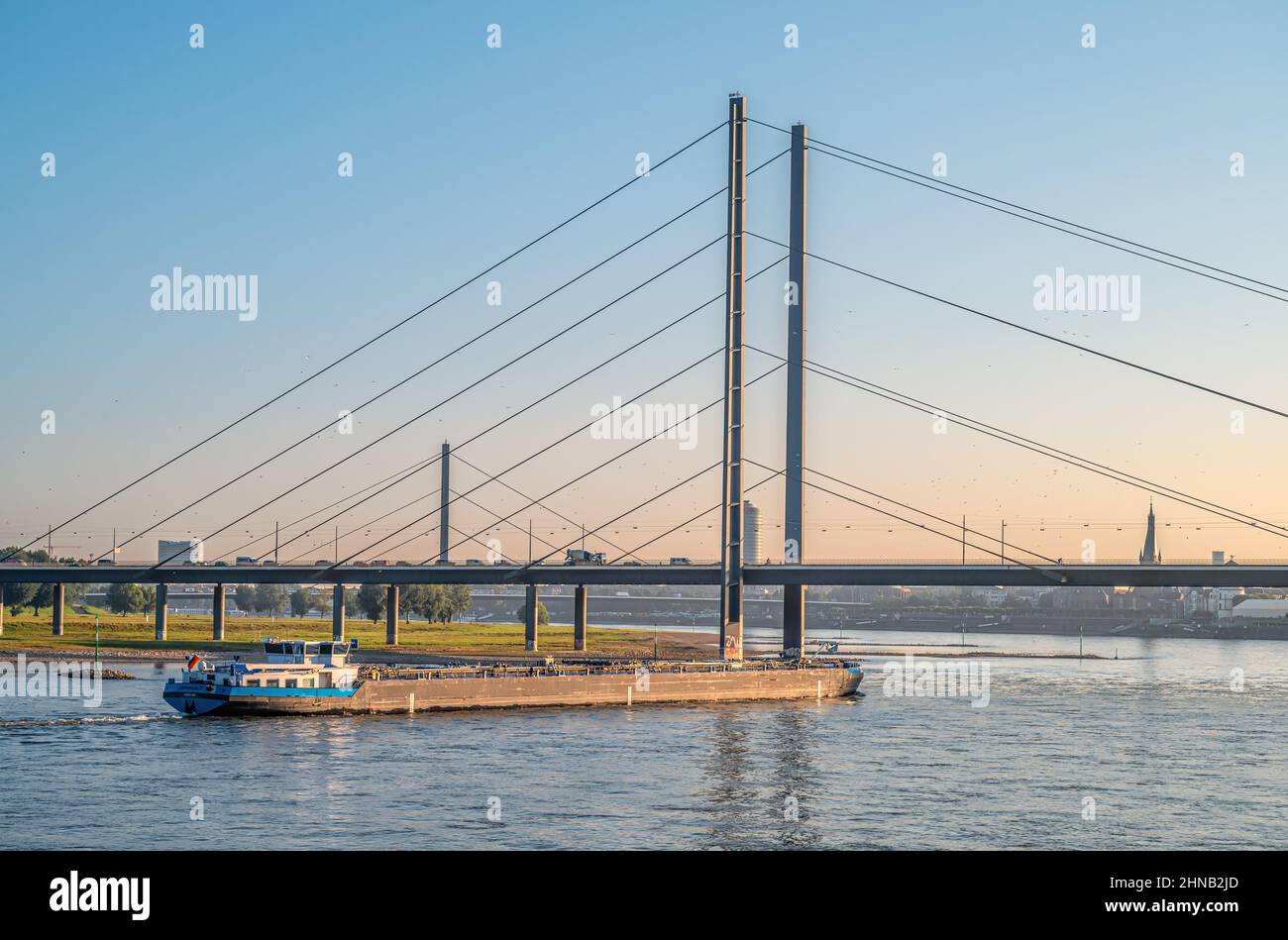 Inland vessel in front of the Duesseldorf Rhine knee bridge at dawn, NRW, Germany Stock Photo