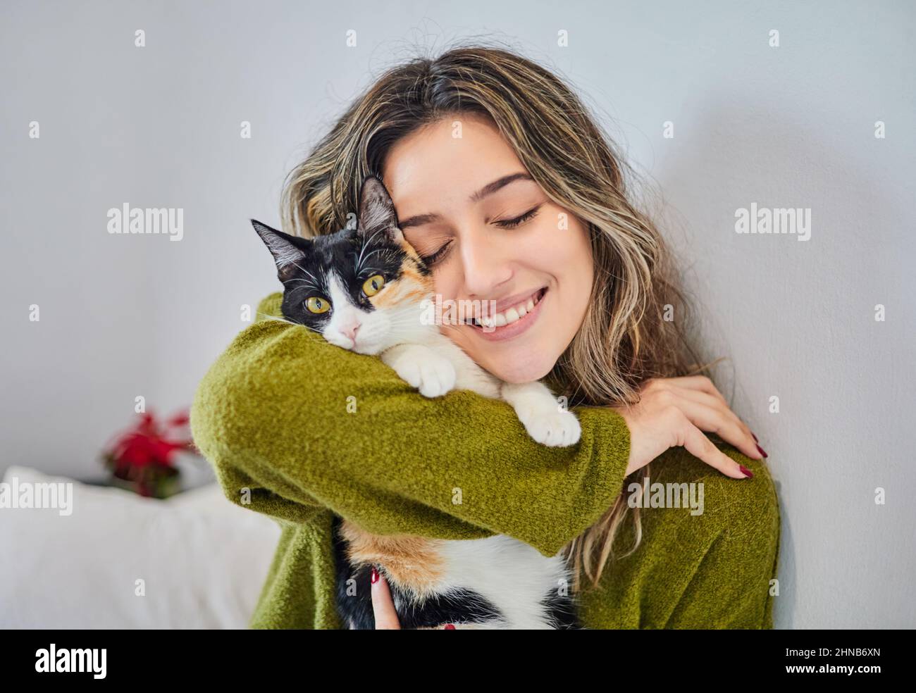 Portrait of a beautiful girl hugging her cat. Love for her feline pet. Stock Photo