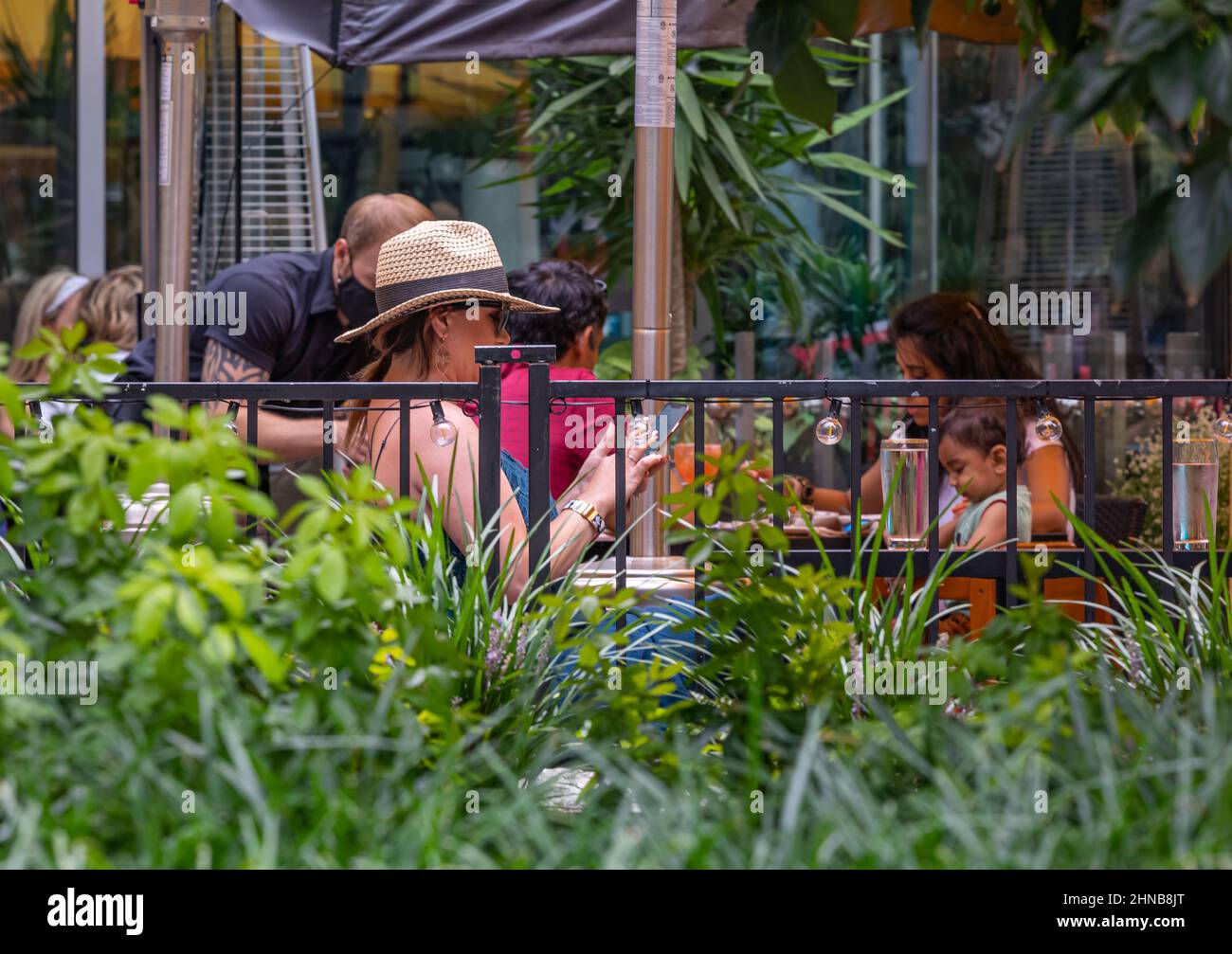 People eating in summer cafe, urban outdoors. Woman sitting in the