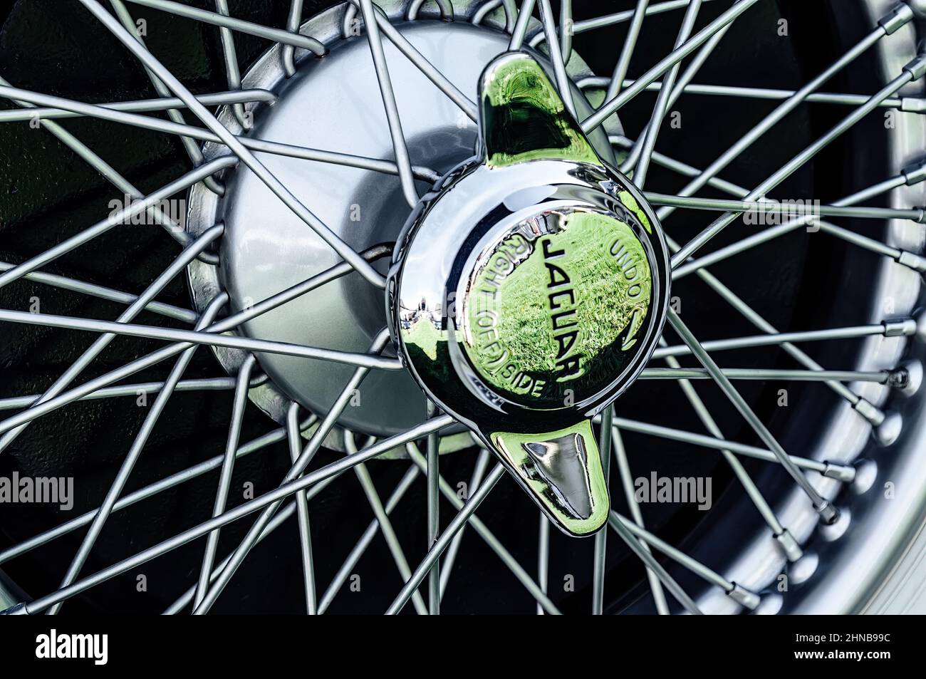 Antique jaguar chrome spoke wheel with emblematic center nut detail Stock Photo