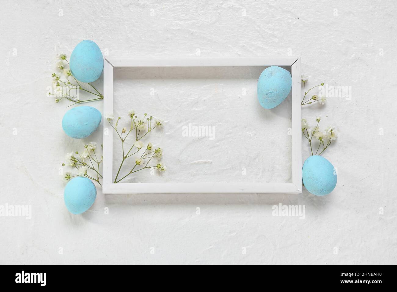 Composition with photo frame, Easter eggs and gypsophila flowers on ...