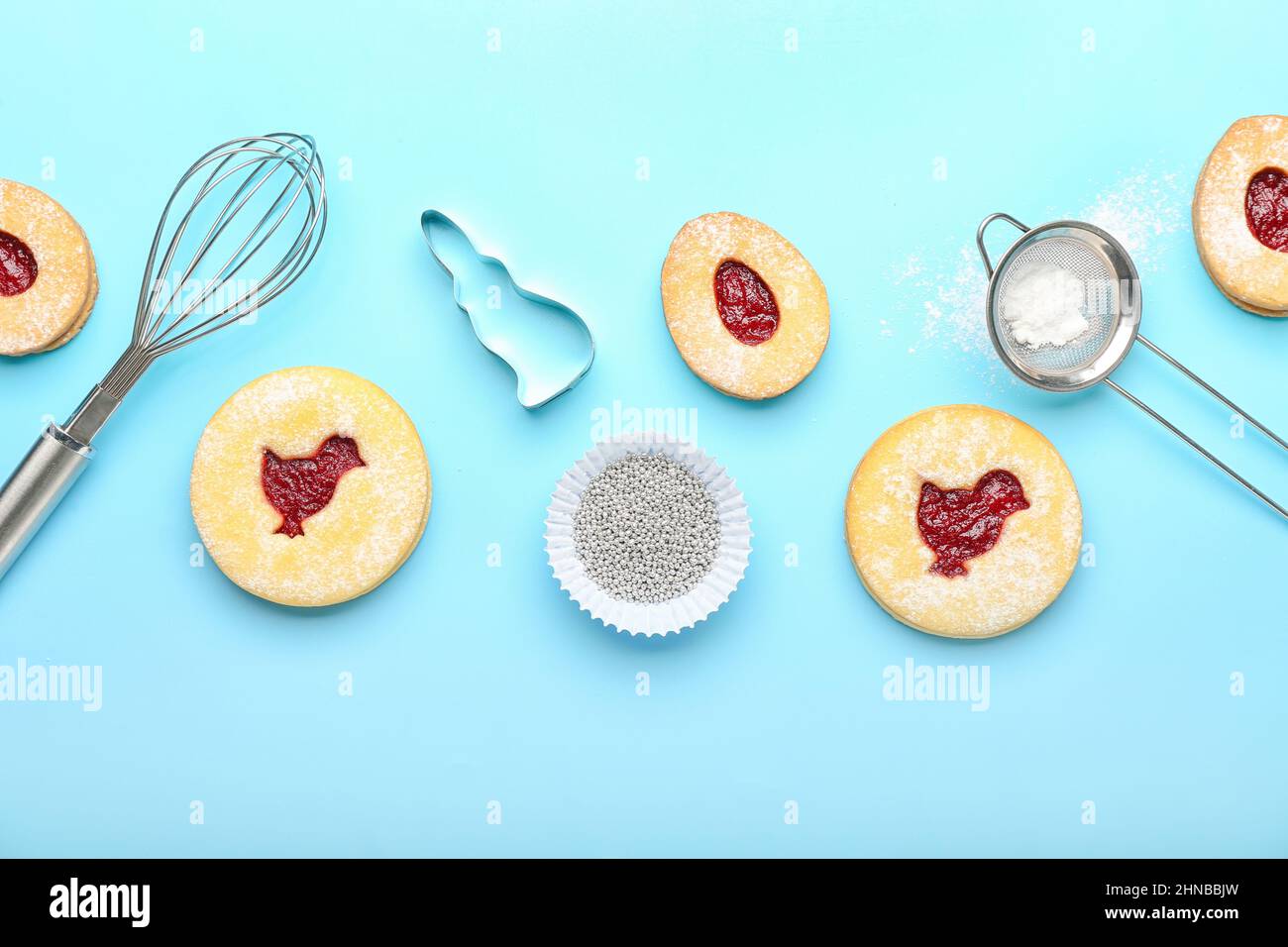 Delicious Easter cookies and utensils on blue background Stock Photo