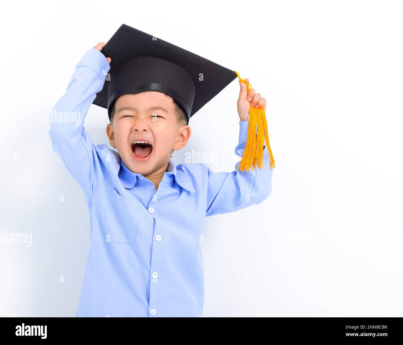 Happy Kid boy in graduation cap and having fun Stock Photo