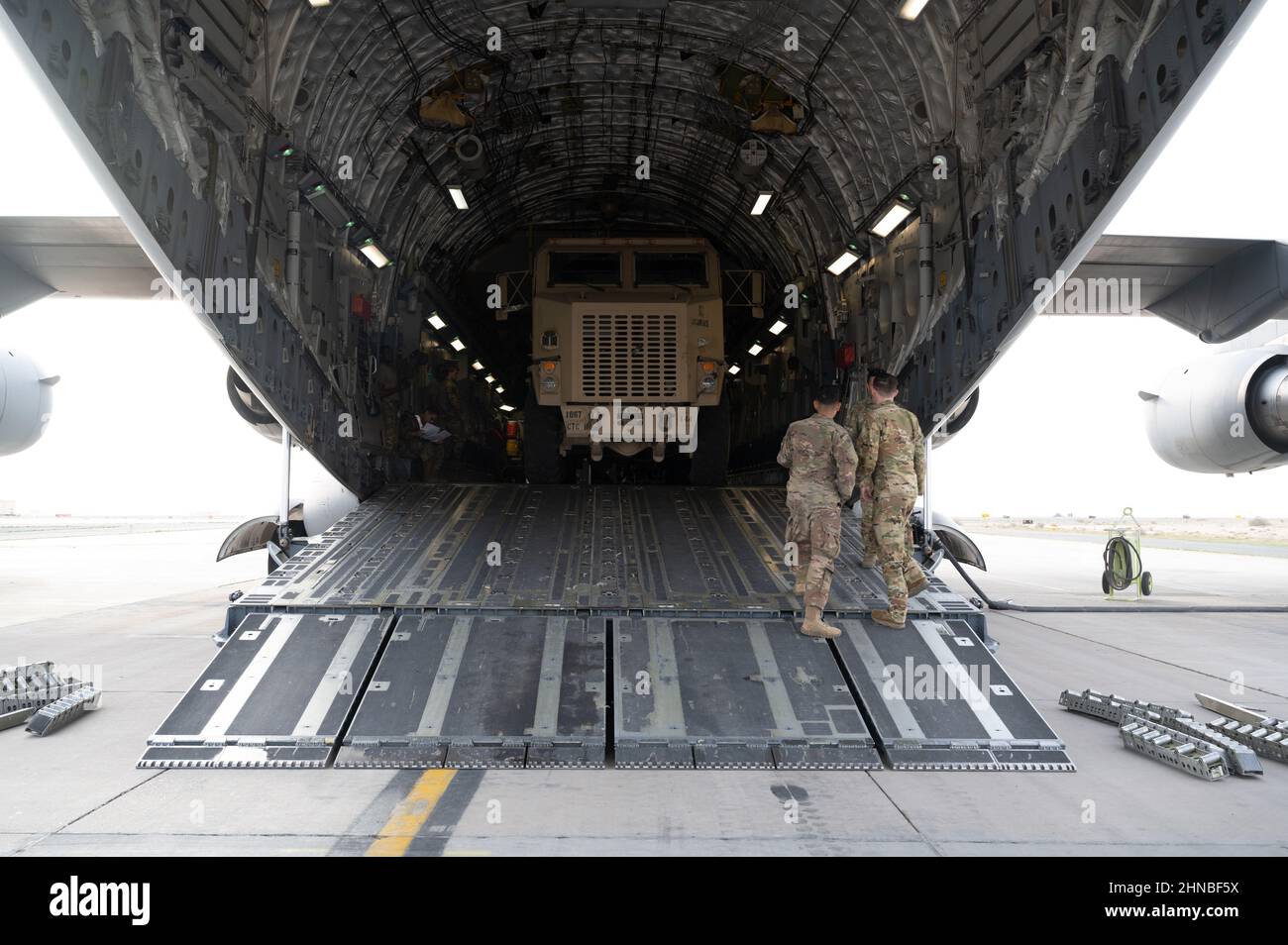 A U.S. Army HET Military Heavy Haul Tractor Truck is loaded onto a U.S. Air Force C-17 Globemaster III at Ali Al Salem, Kuwait, Feb. 10, 2022.  The C-17 Globemaster III is the most flexible cargo aircraft to enter the airlift force allowing cargo to be loaded onto the C-17 through a large rear ramp and door system that accommodates virtually all of the Army’s air-transportable equipment such as a 69-ton M1 Abrams main battle tank, armored vehicles, trucks and trailers.  (U.S. Air Force photo by Senior Airman Daira Jackson) Stock Photo