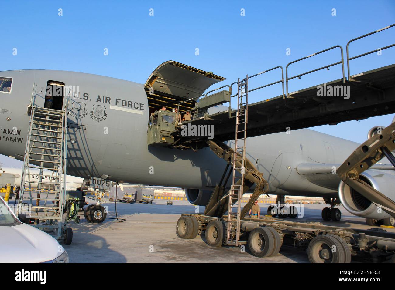 Aerial Port and aircrew Airmen unload cargo from a K-loader into a KC ...