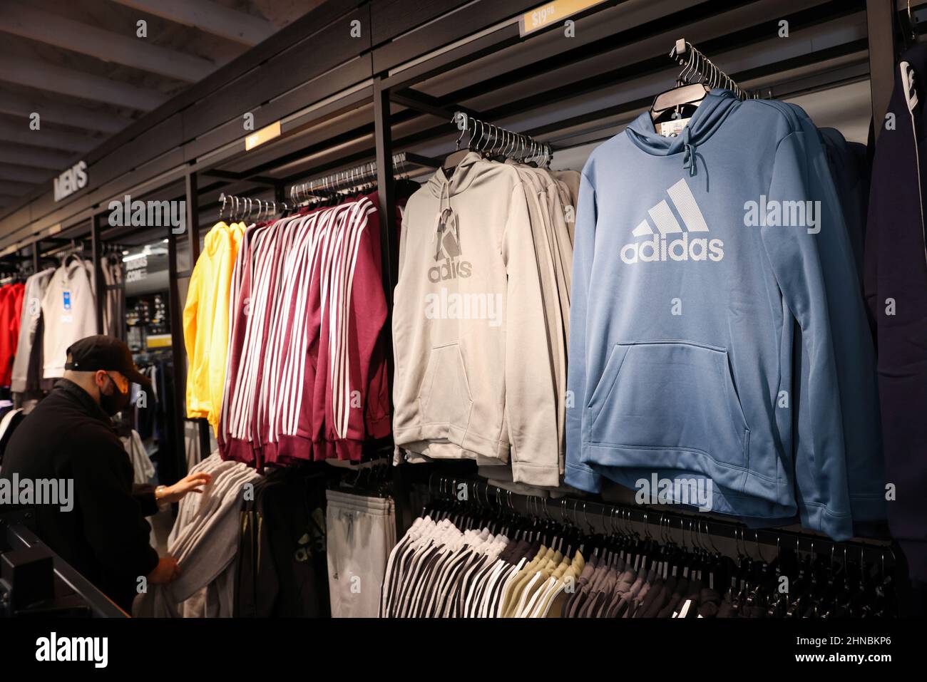 A person looks at clothes in the Adidas store at the Woodbury Common  Premium Outlets in Central Valley, New York, U.S., February 15, 2022.  REUTERS/Andrew Kelly Stock Photo - Alamy