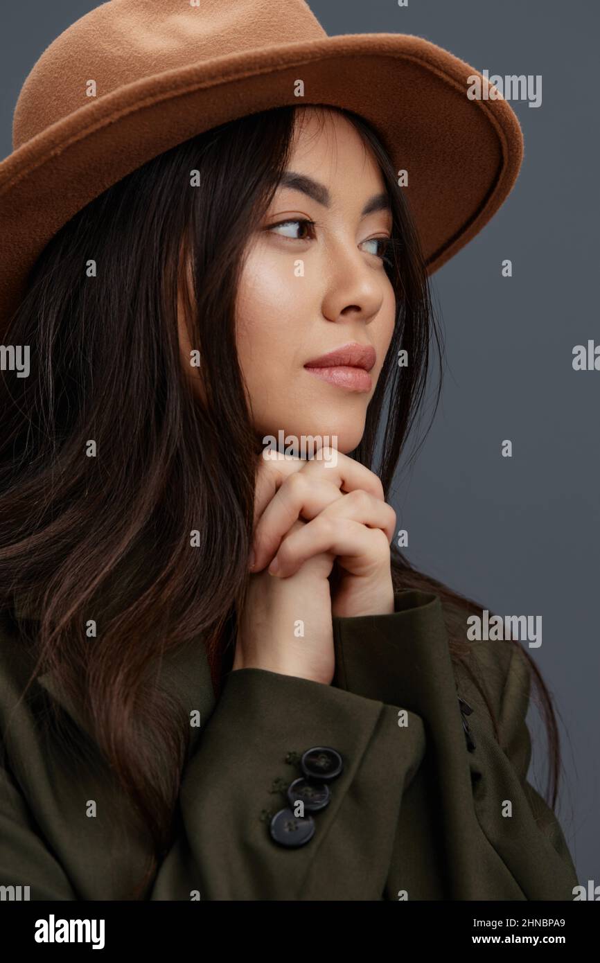 beautiful woman in a suit with a hat posing casual wear Gray background